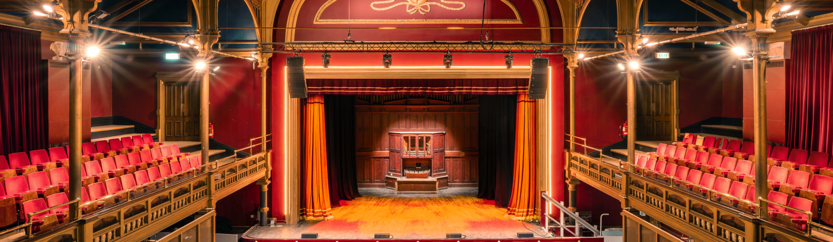 Photograph of the stage at Hartlepool Town Hall Theatre with red seats and red curtains