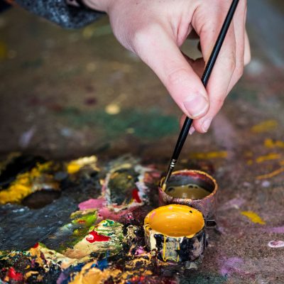 high-angle-close-up-of-human-hand-dipping-paintbru-2025-04-05-03-11-54-utc